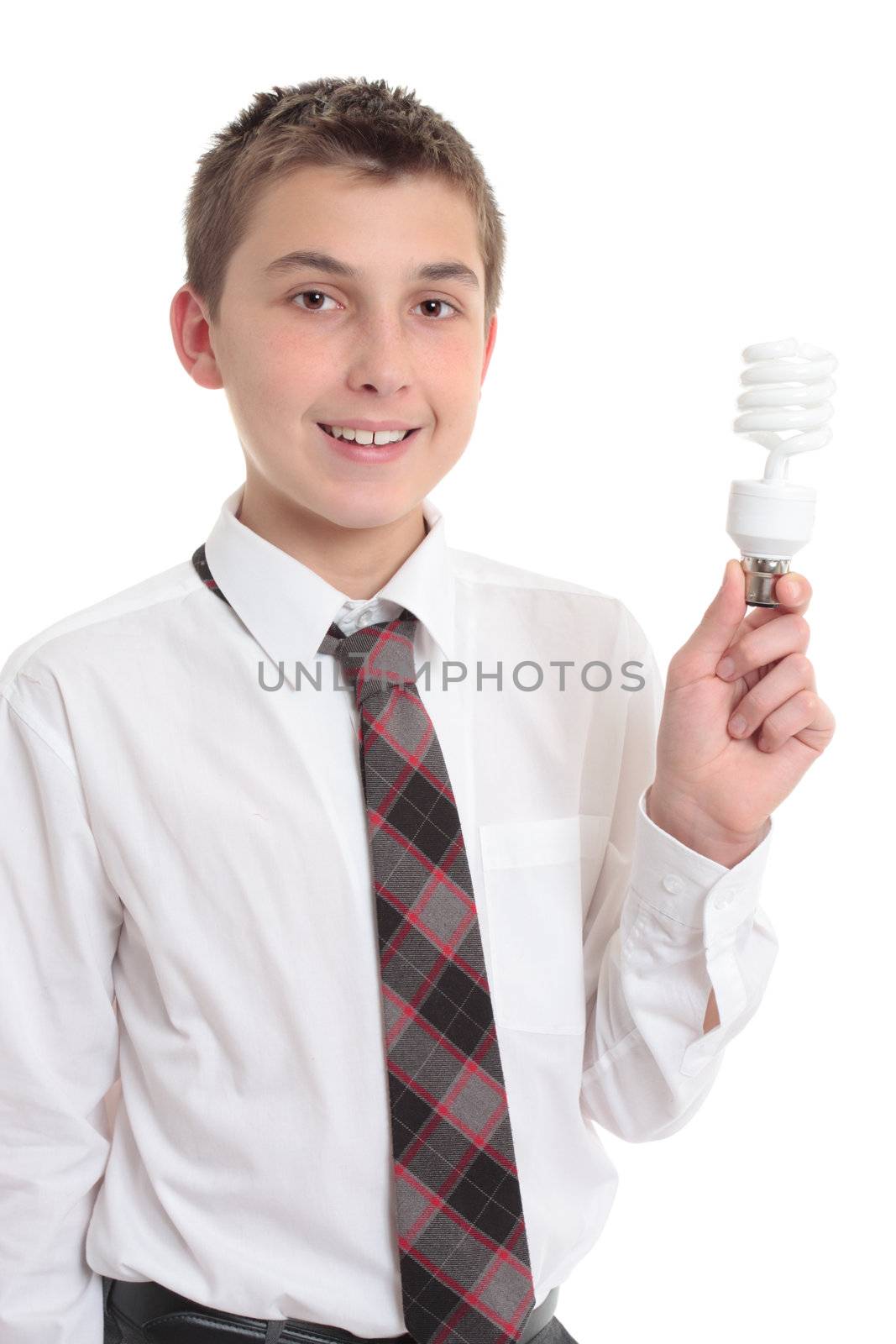 A smiling high school student holds an eco friendly fluorescent light bulb in his hand.