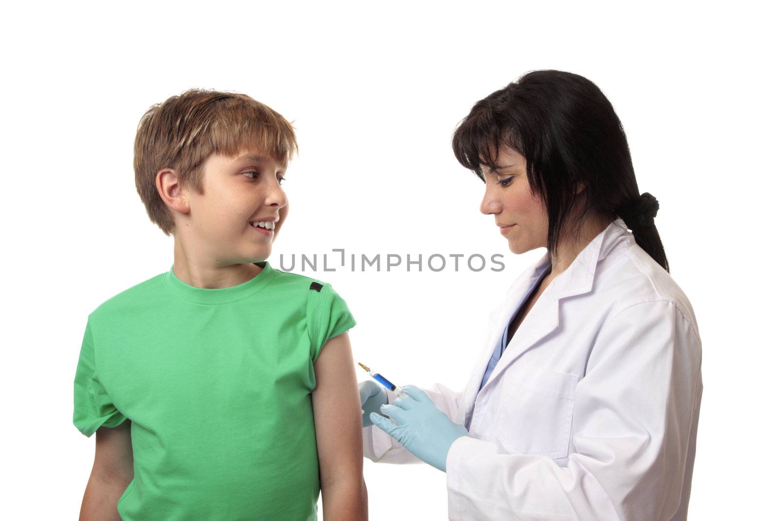 A happy boy receives a vaccination shot against a disease, virus or flu in his arm by a doctor or nurse.