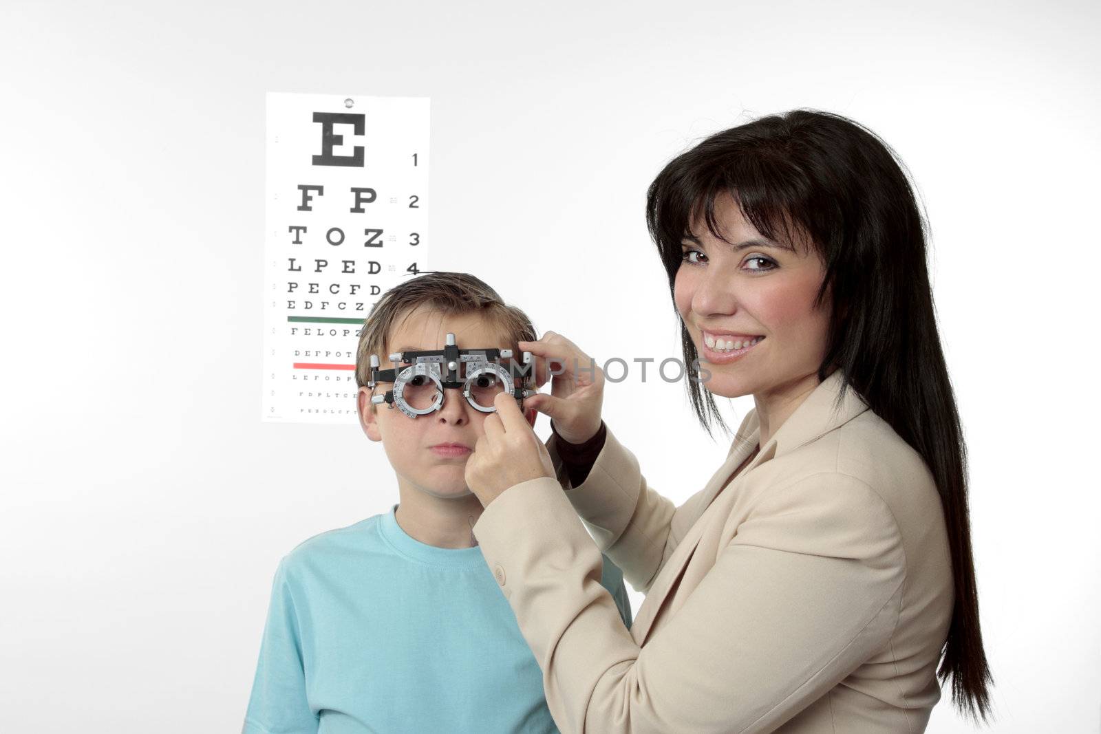 An optometrist putting trial frames on a child.  She is looking around and smiling.
