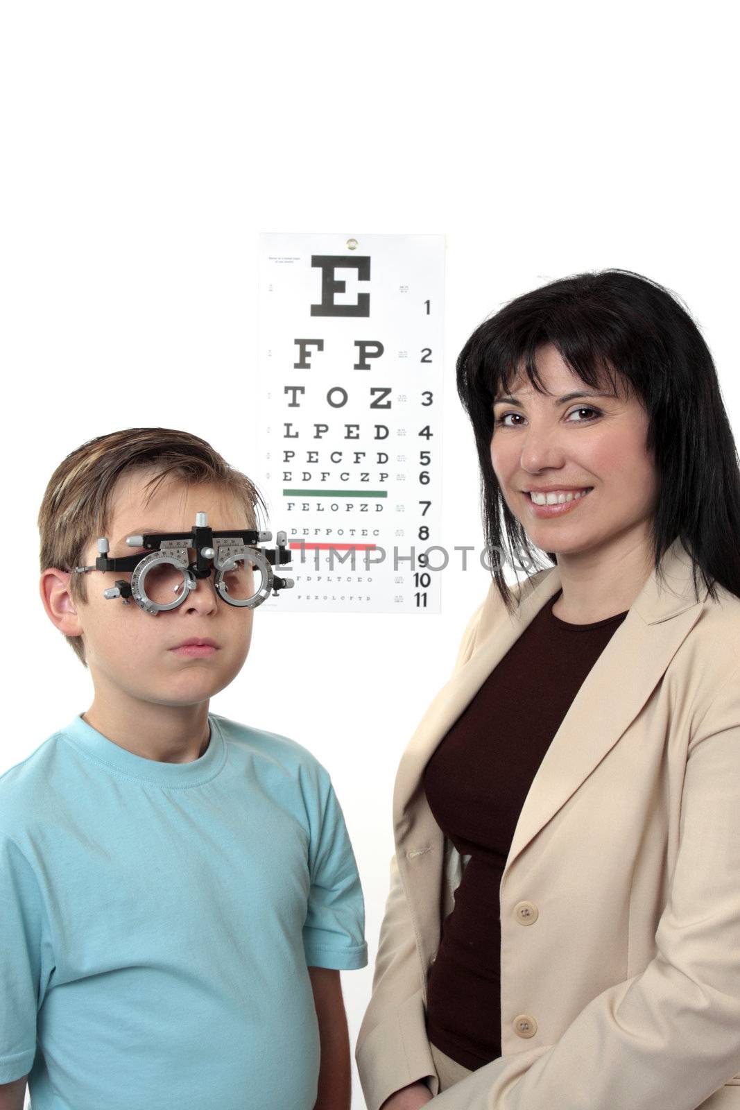 An eye doctor stands with a patient who is wearing trial frames during examination.