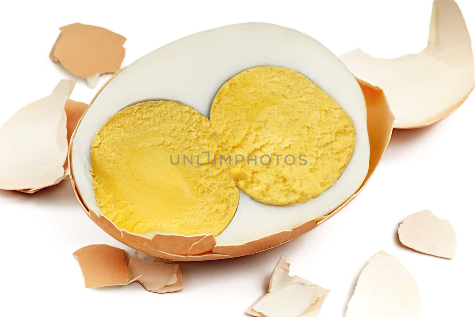 Halved hard-boiled egg with two egg yolks on a white background. Macro.