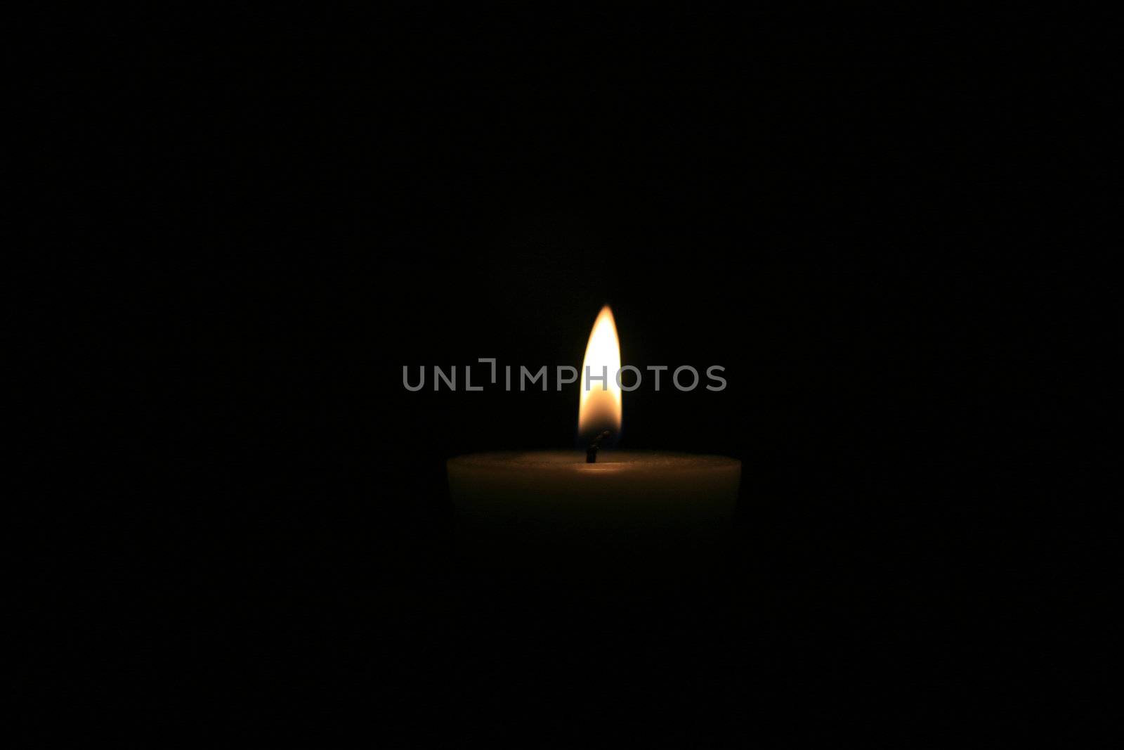 single candle brightly lit close up with nice flame
