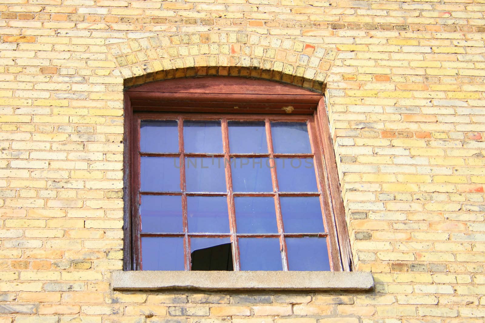 a single window with a broken pane of glass, in an old abandoned paper mill
