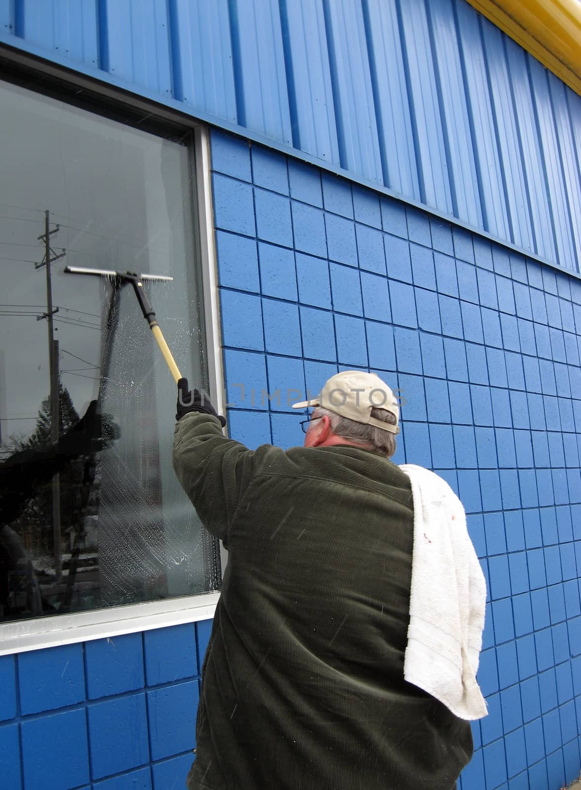 professional commercial window washer cleaning windows at a business
