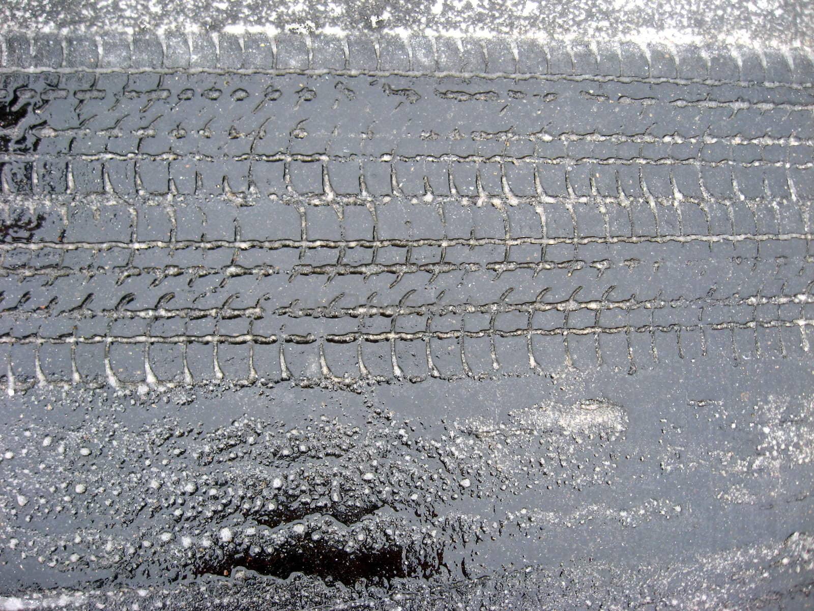 horizontal tire tracks on pavement in fresh wet snow