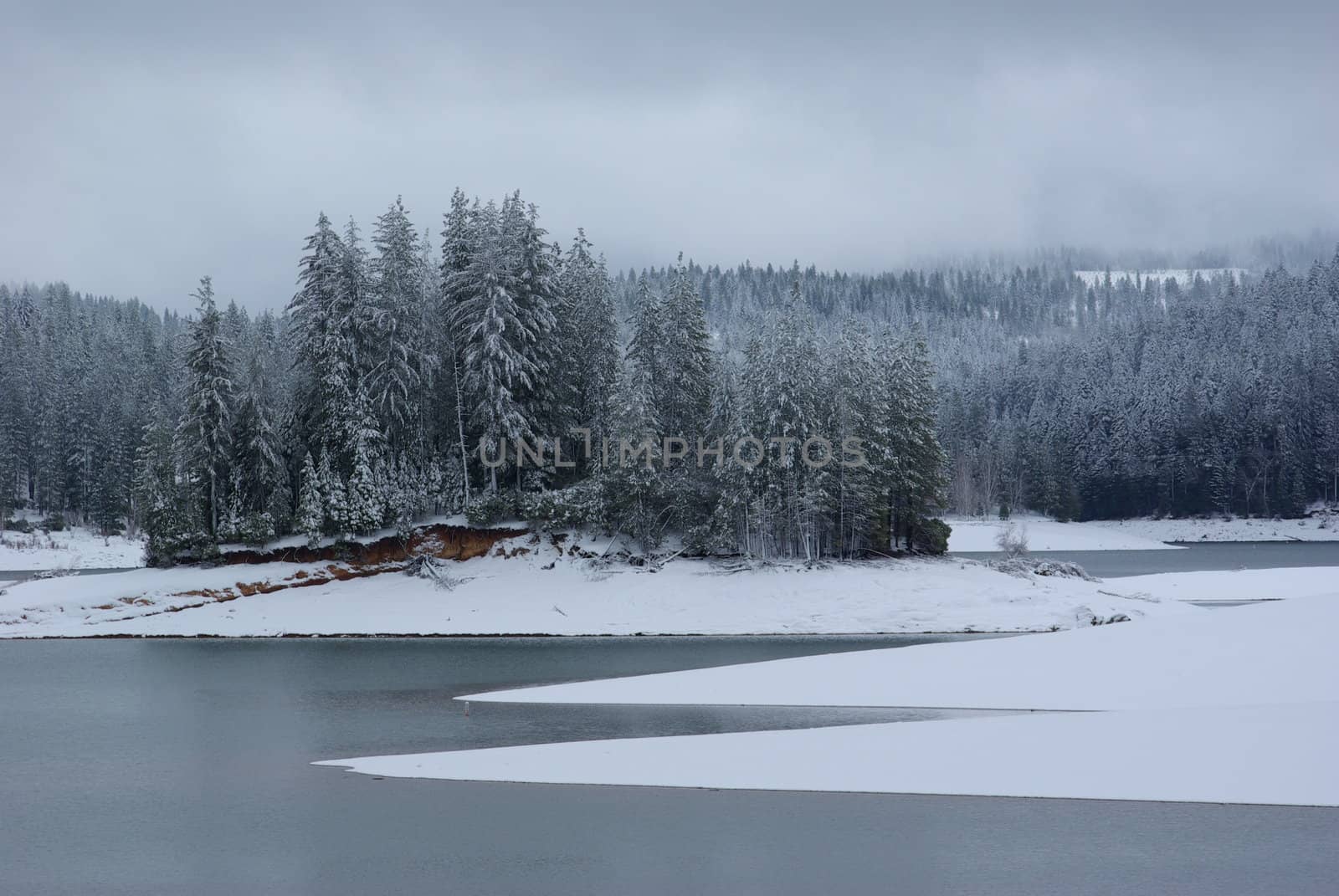 Snow covered shoreline on a sierra mountain lake