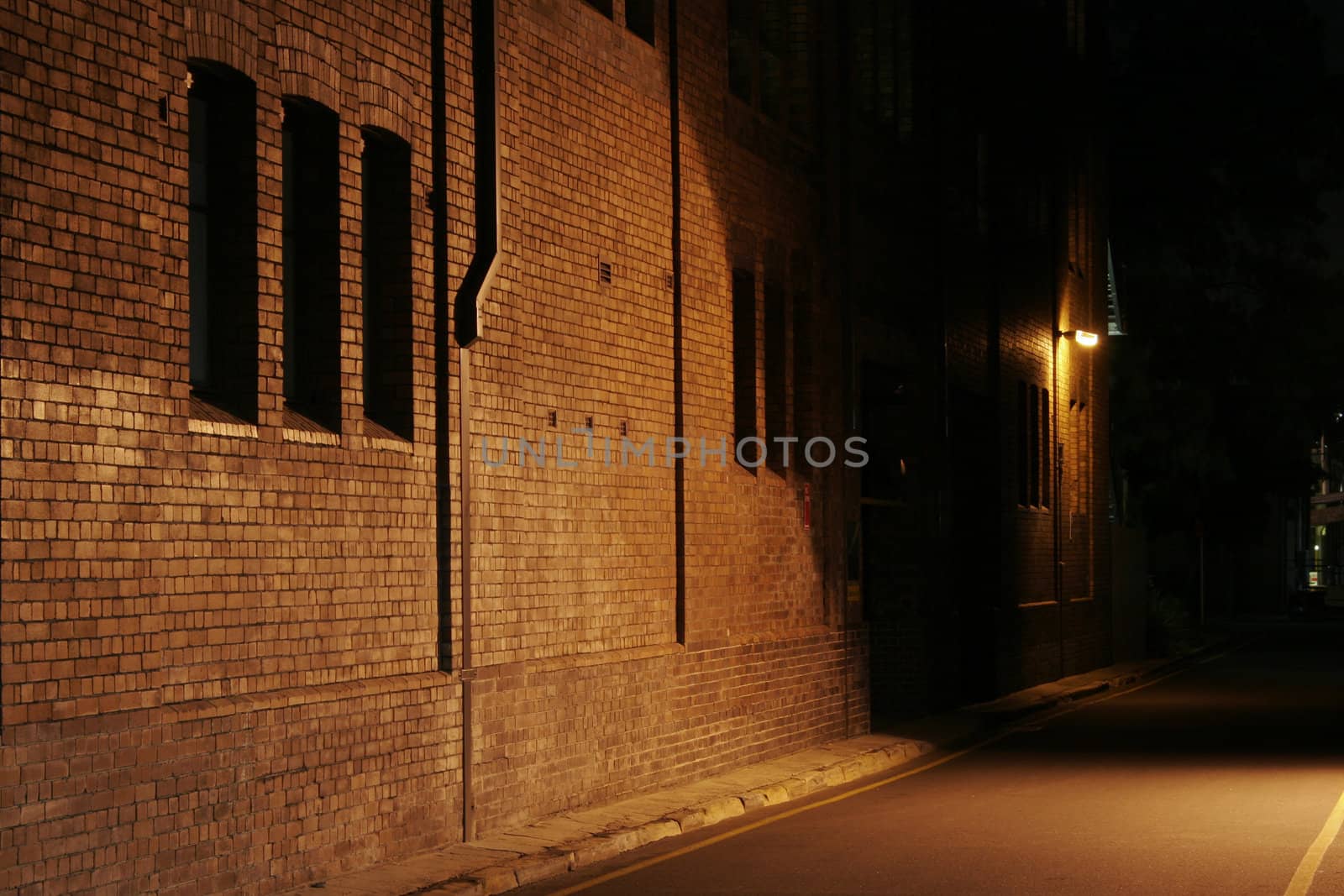 Mysterious Alley - Dark Abandoned Street With Lights Shining On A Brick Wall