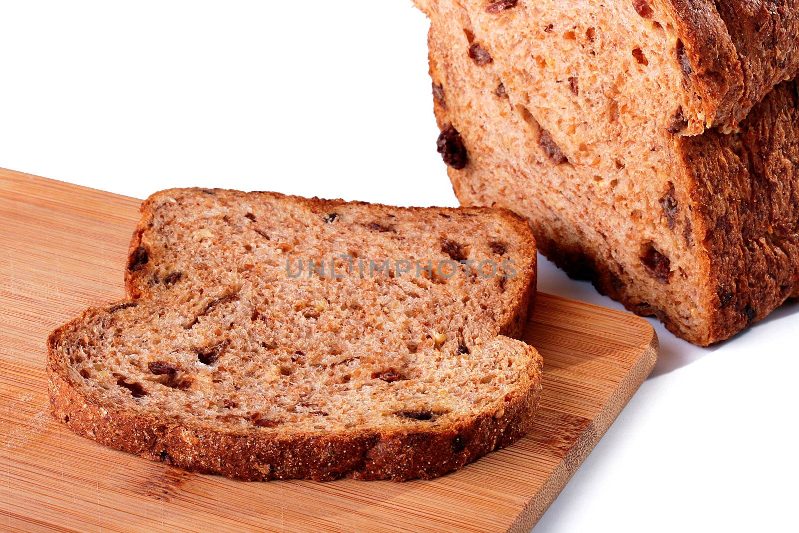 Slice of the cut off bread with raisin on a kitchen board.