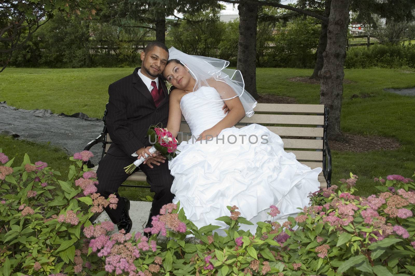 Just married multi ethnic couple kissing under an umbrella