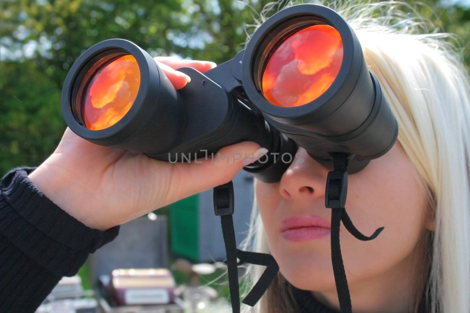 Blonde girl with big binocular seeing the sky