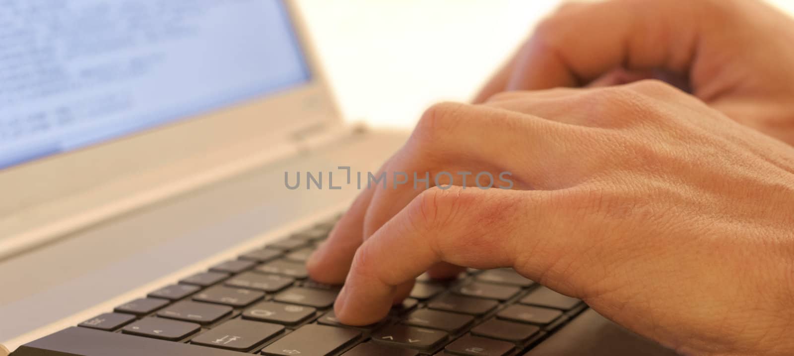 Hands typing on a laptops keyboard