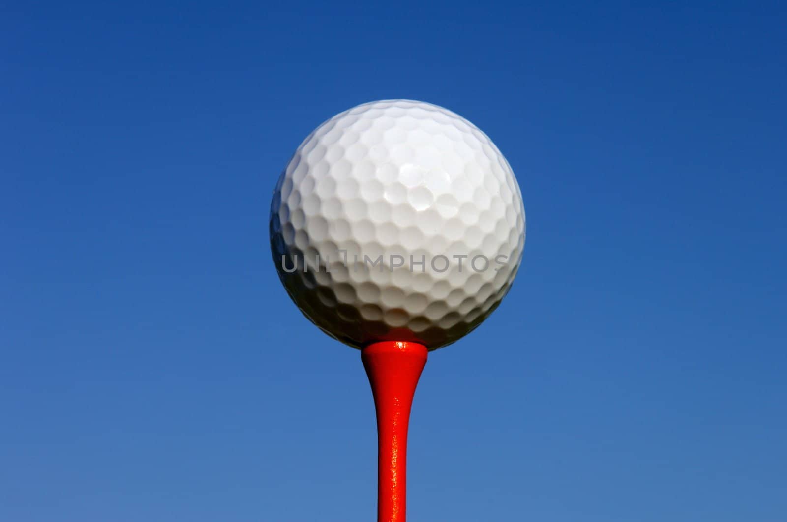 Image of a white golf ball sitting on a red tee