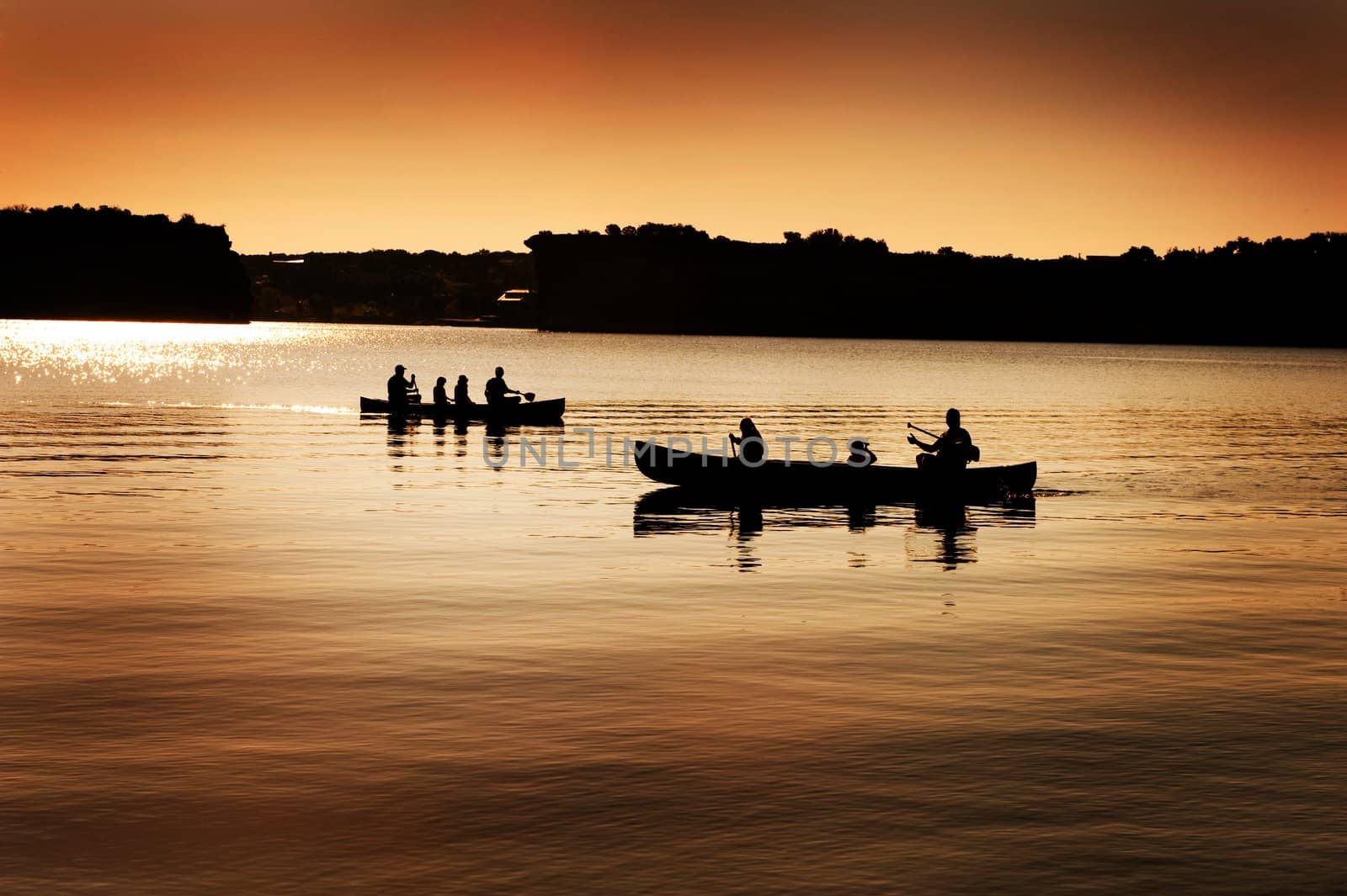 Image of silhouette of canoers on a lake