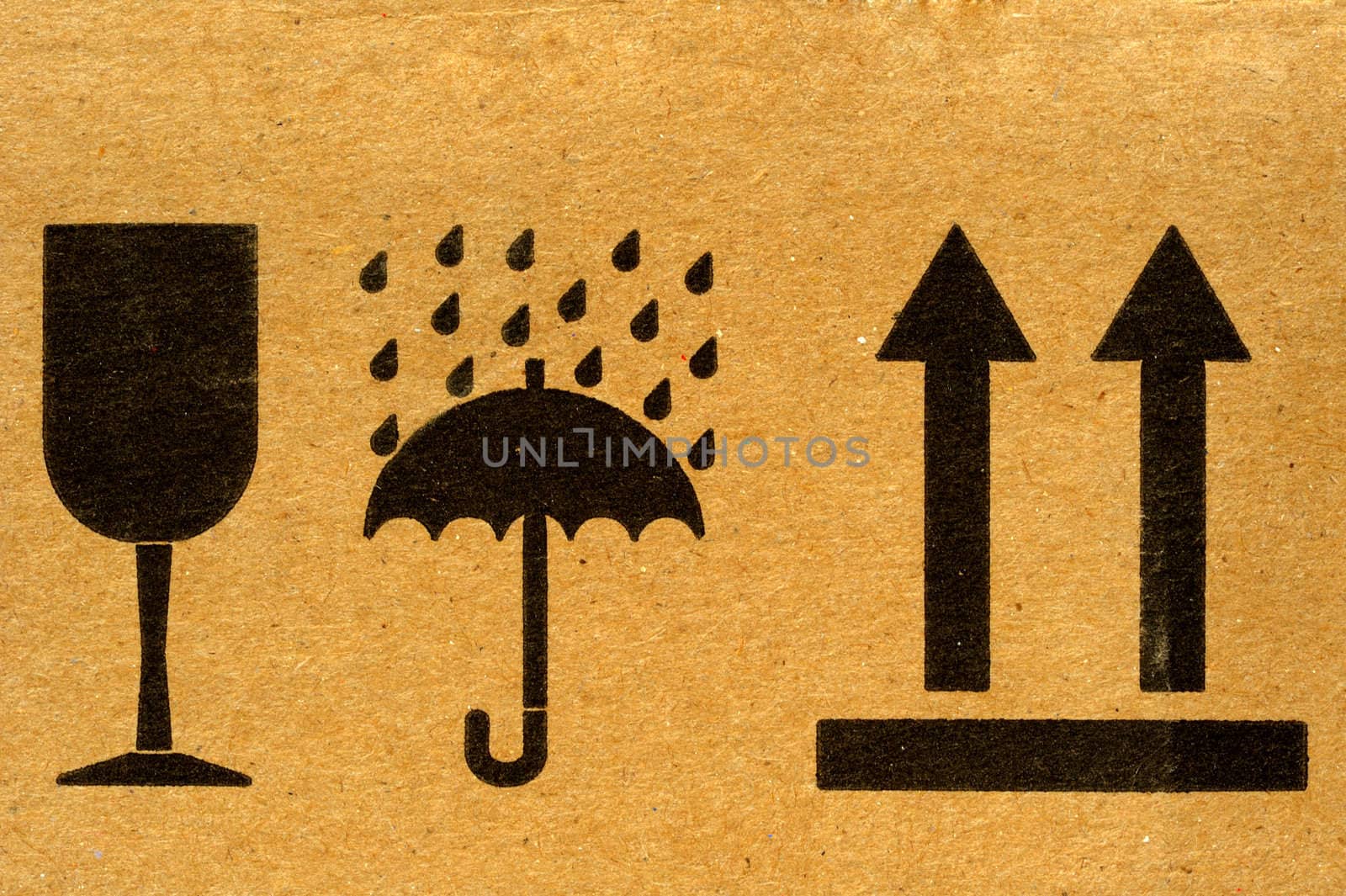 The symbols 'fragile', 'keep dry' and 'this way up' on cardboard.