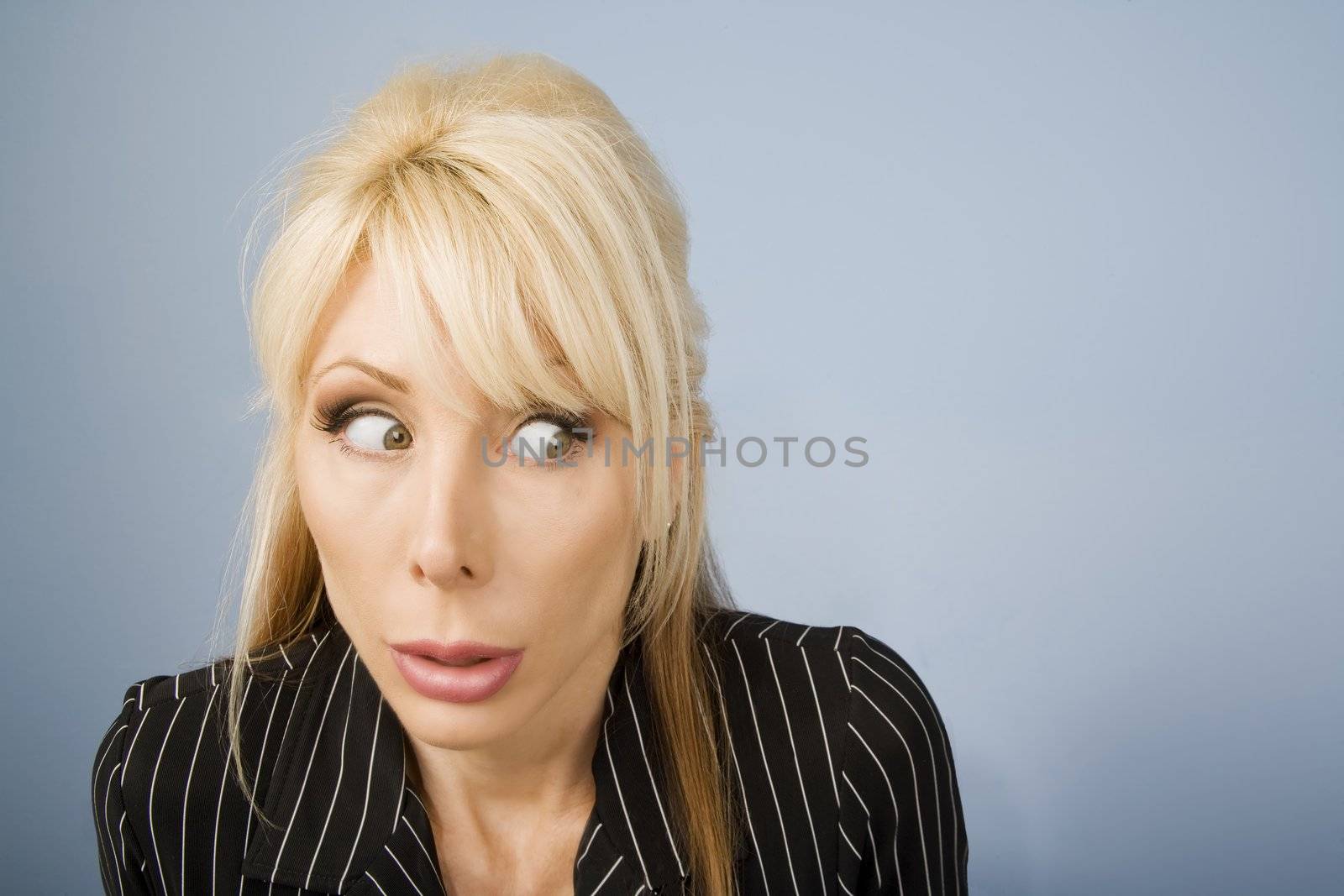 Close Up of an Apprehensive blonde businesswoman in front of a blue background