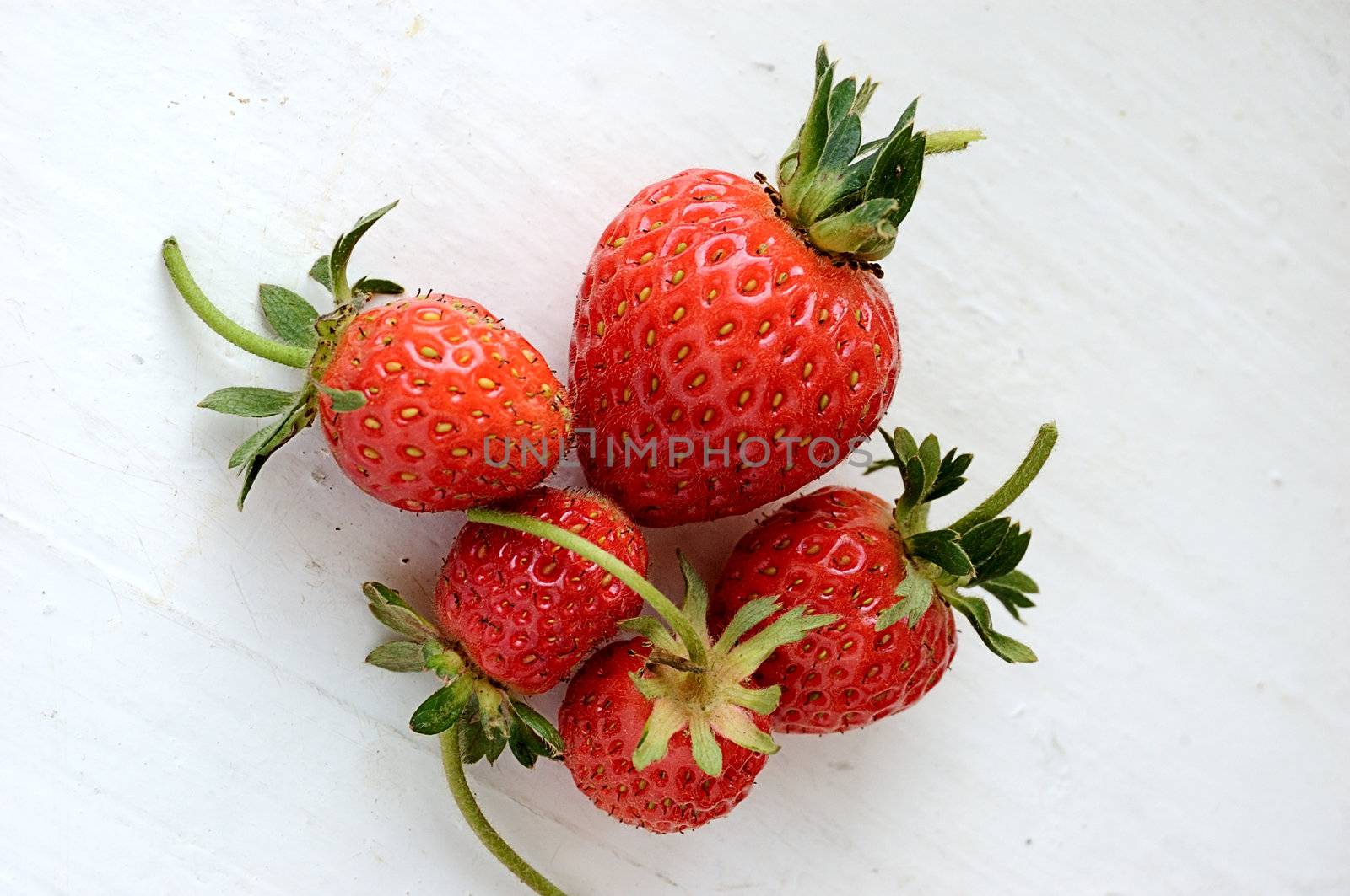 set of fresh strawberries on white painted board