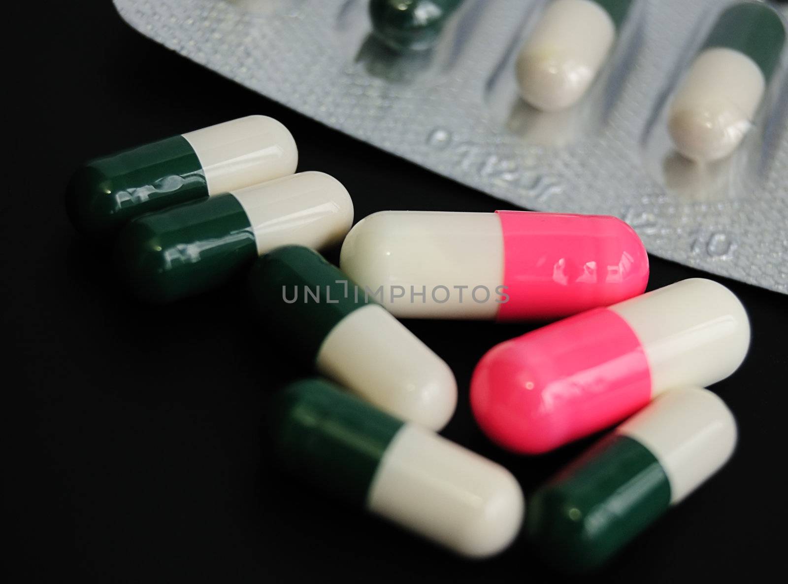 drugs or vitamines? seven capsules on black