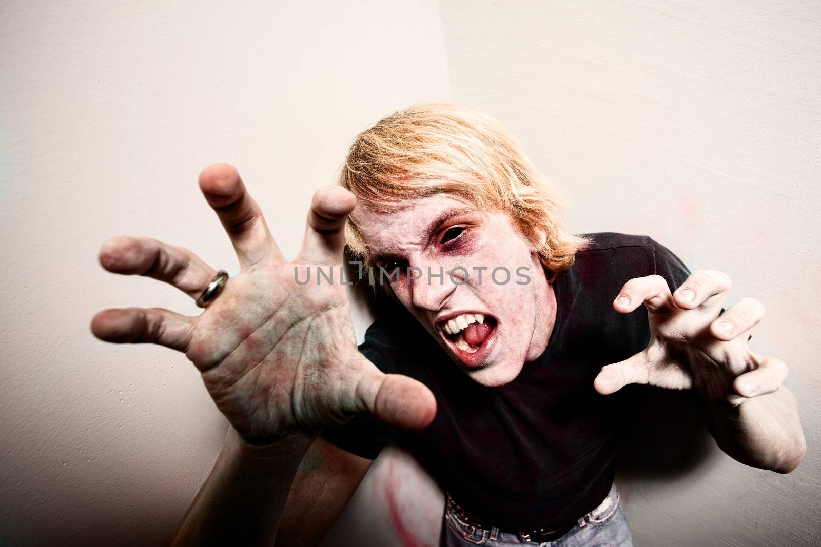 Young male zombie or vampire trapped in a corner