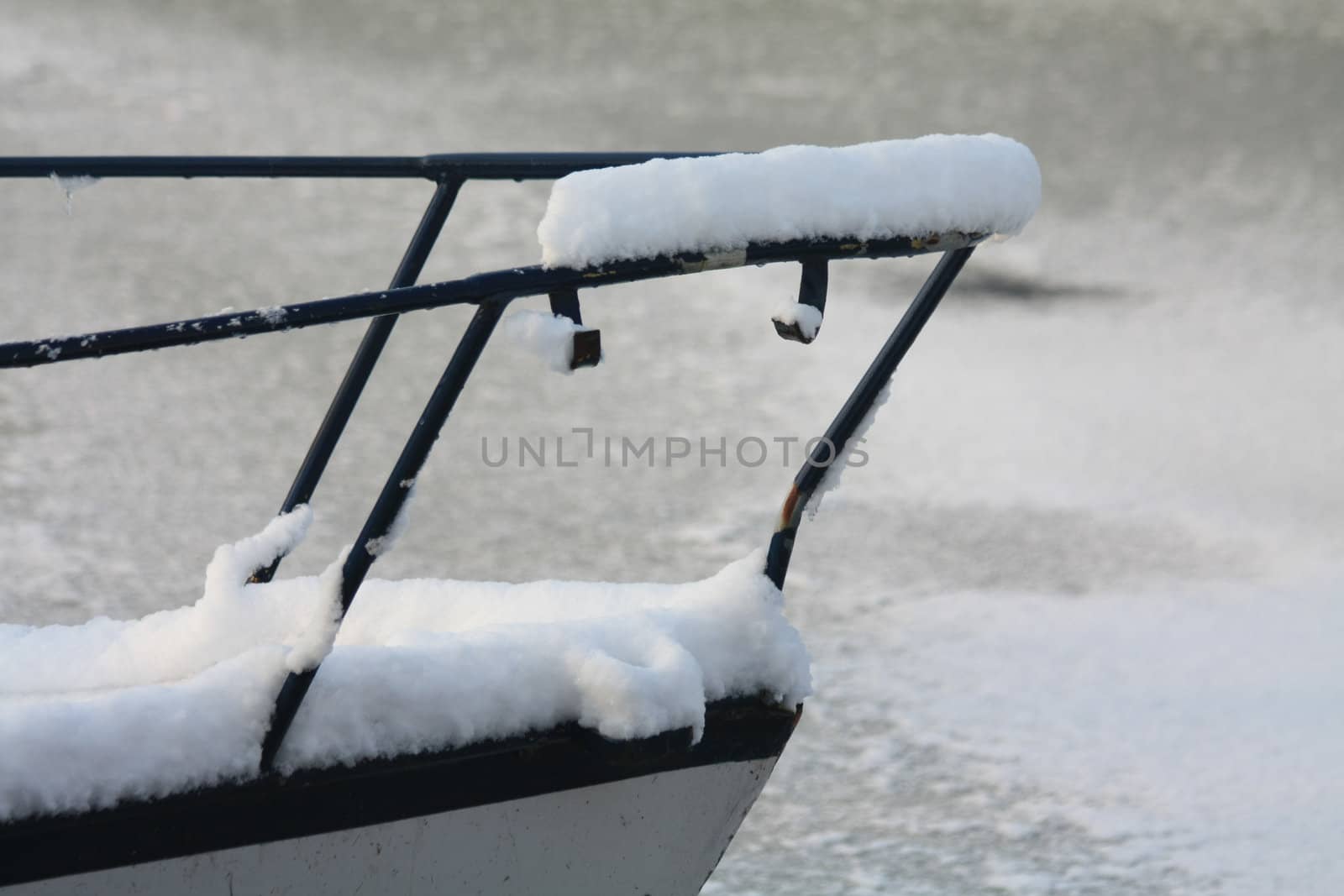 A detail of a boat covered in snow in a canal