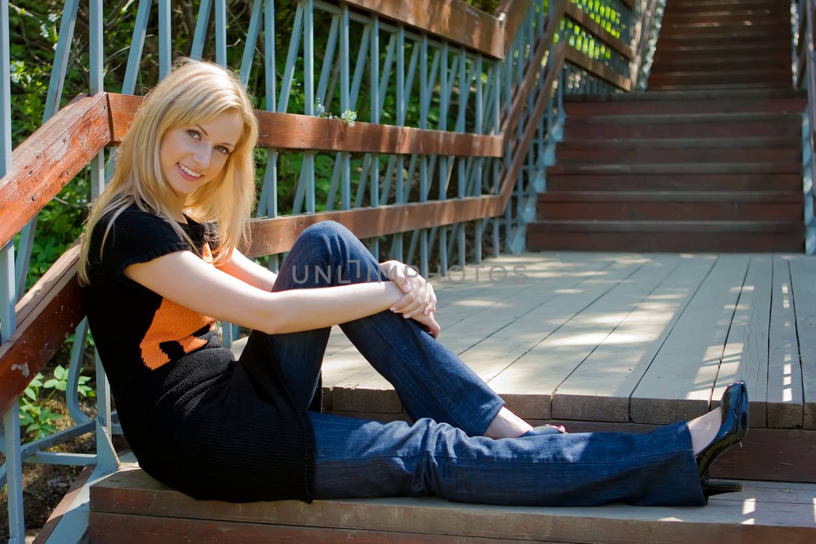 The beautiful girl sits at ladder steps