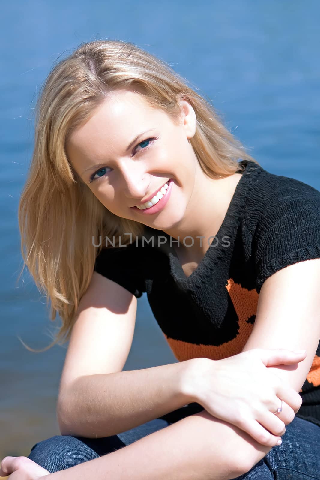 The beautiful girl on the bank of the summer river