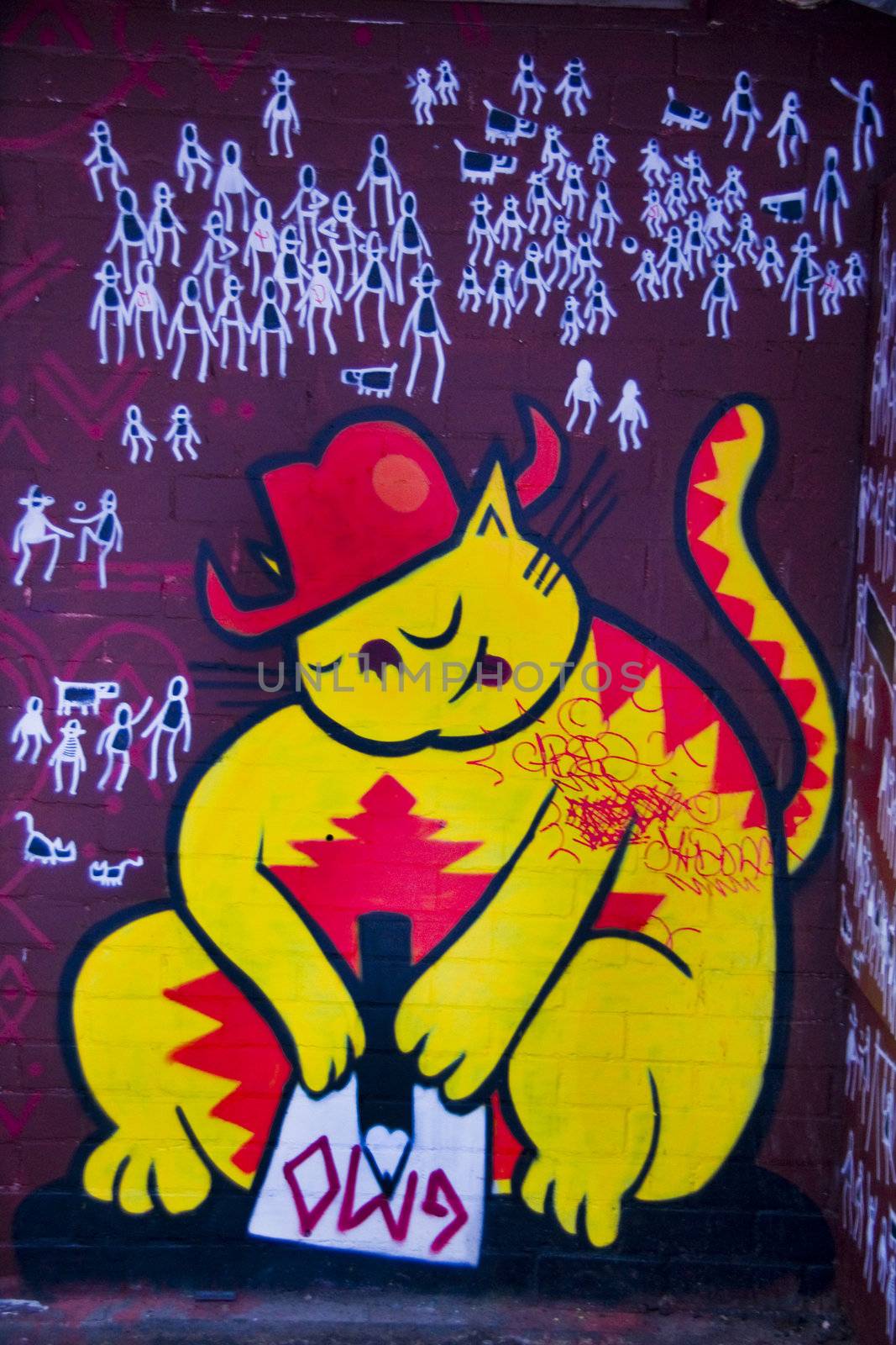 Graffiti cartoon yellow cat with red hat on purple wall in urban alley in Melbourne Australia. Cat writes the word good, unblemished figure.