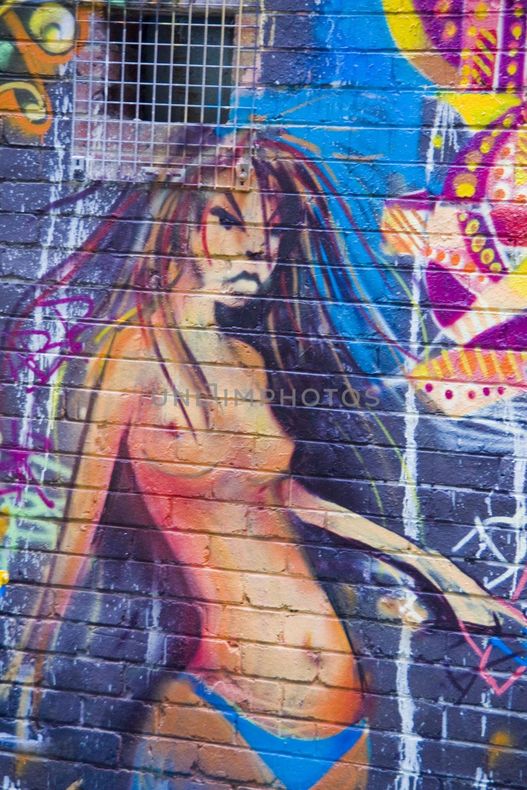 Graffiti angry girl in monokini on blue wall in an urban alley in Melbourne Australia. Unblemished figure.