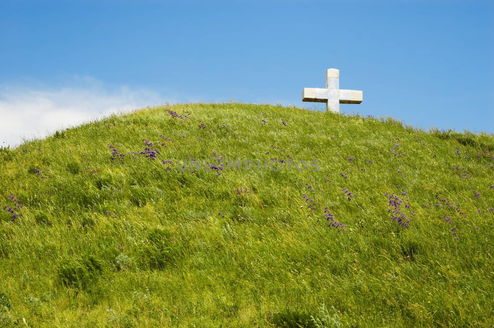 christian cross on the top of green hill