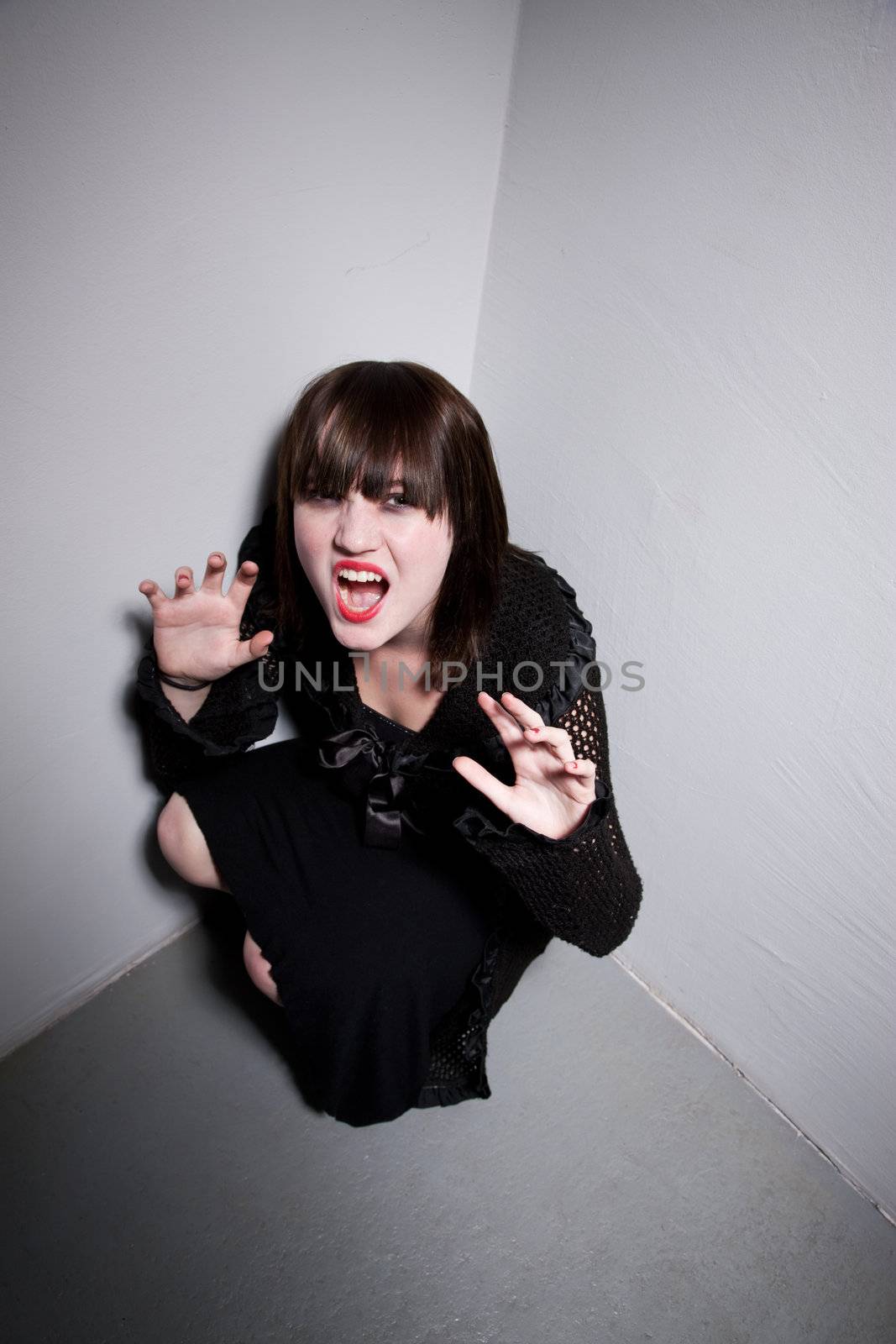 Frghtened young goth girltrapped in a corner