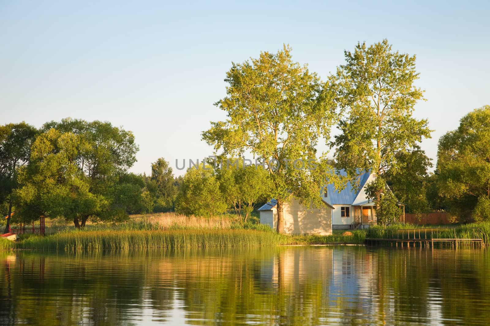 The lake, trees and house reflected in water