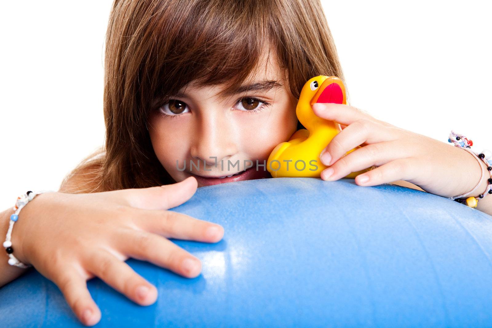 Happy little child smilling and playing with a yellow rubber duck
