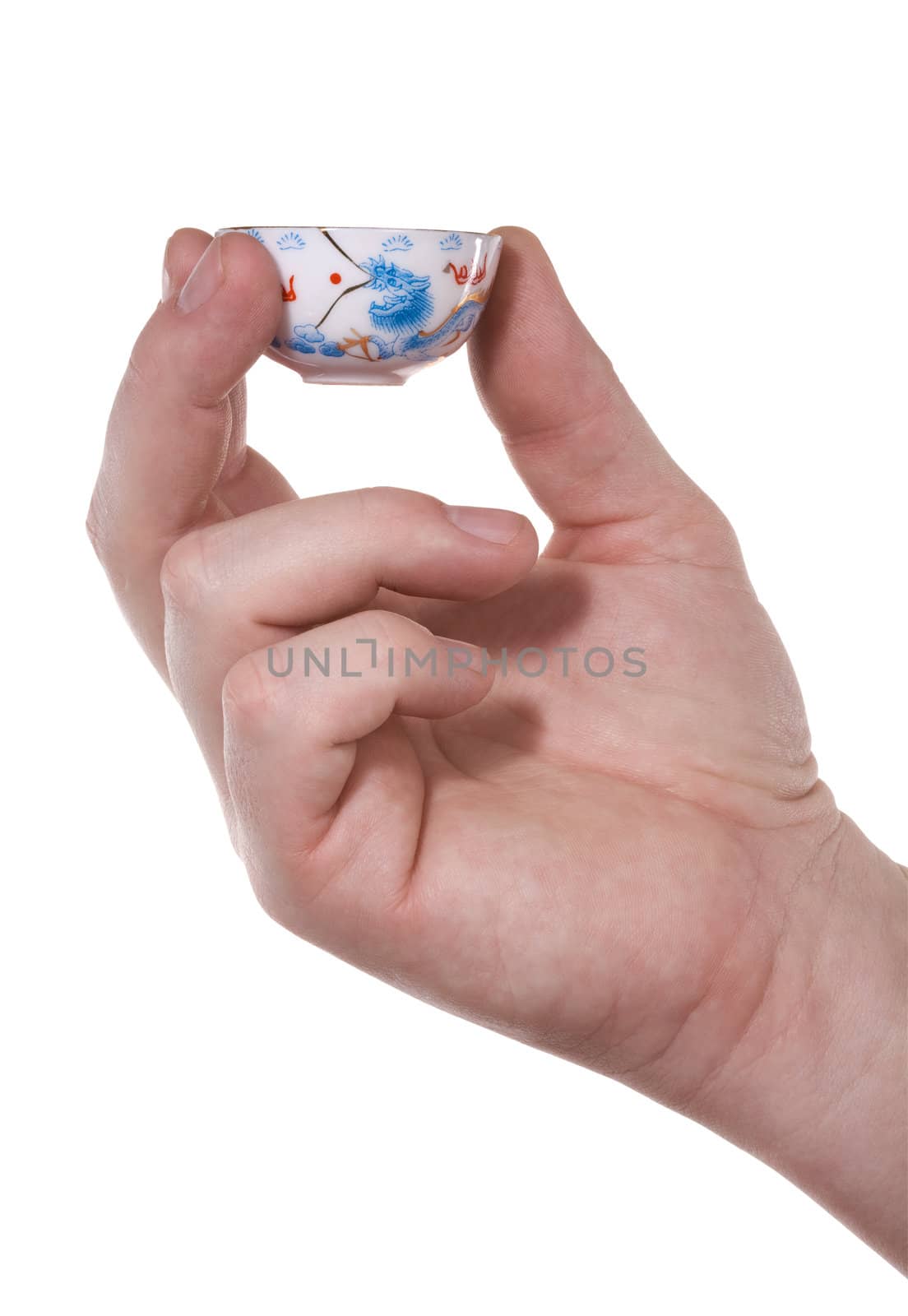 The hand holds a small cup in oriental style. Isolated on white [with clipping path].