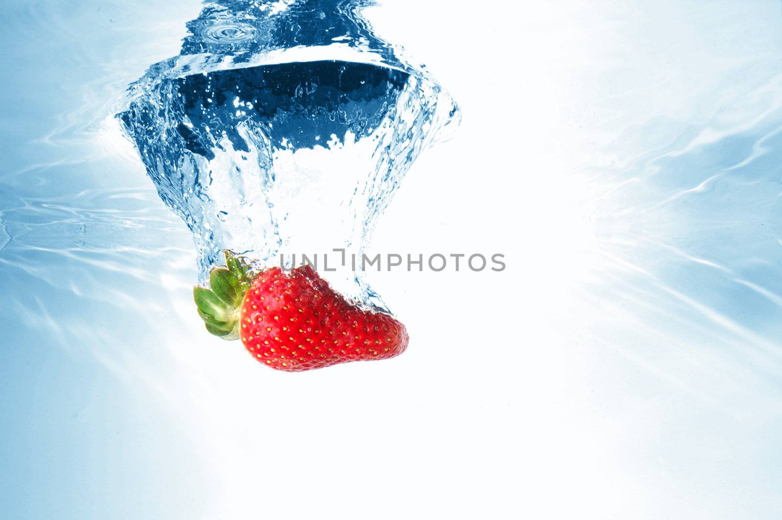 strawberry splash in warter showing healthy lifestyle