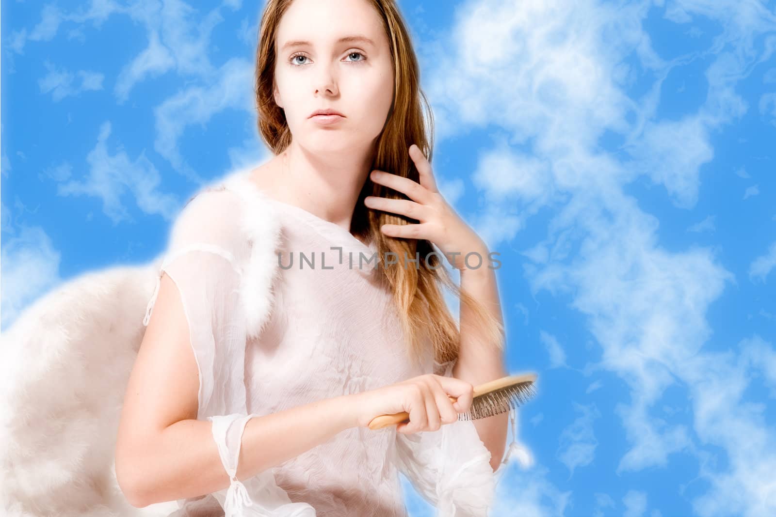 Portrait of an angel in the clouds who is brushing her hair