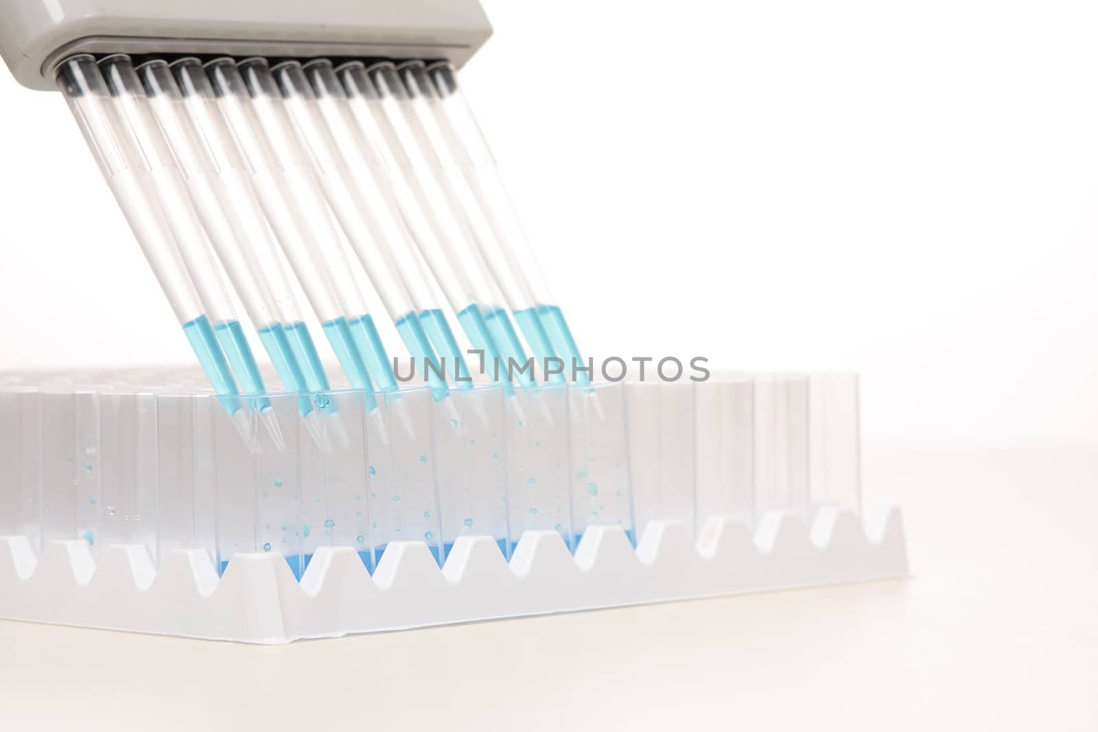 Electronic pipettors can be programmed to aspirate, mix and dispense variable volumes.  When dispensing it is recommended the pipette be held at a 45 degree angle.  Focus to foreground shallow dof with copyspace.