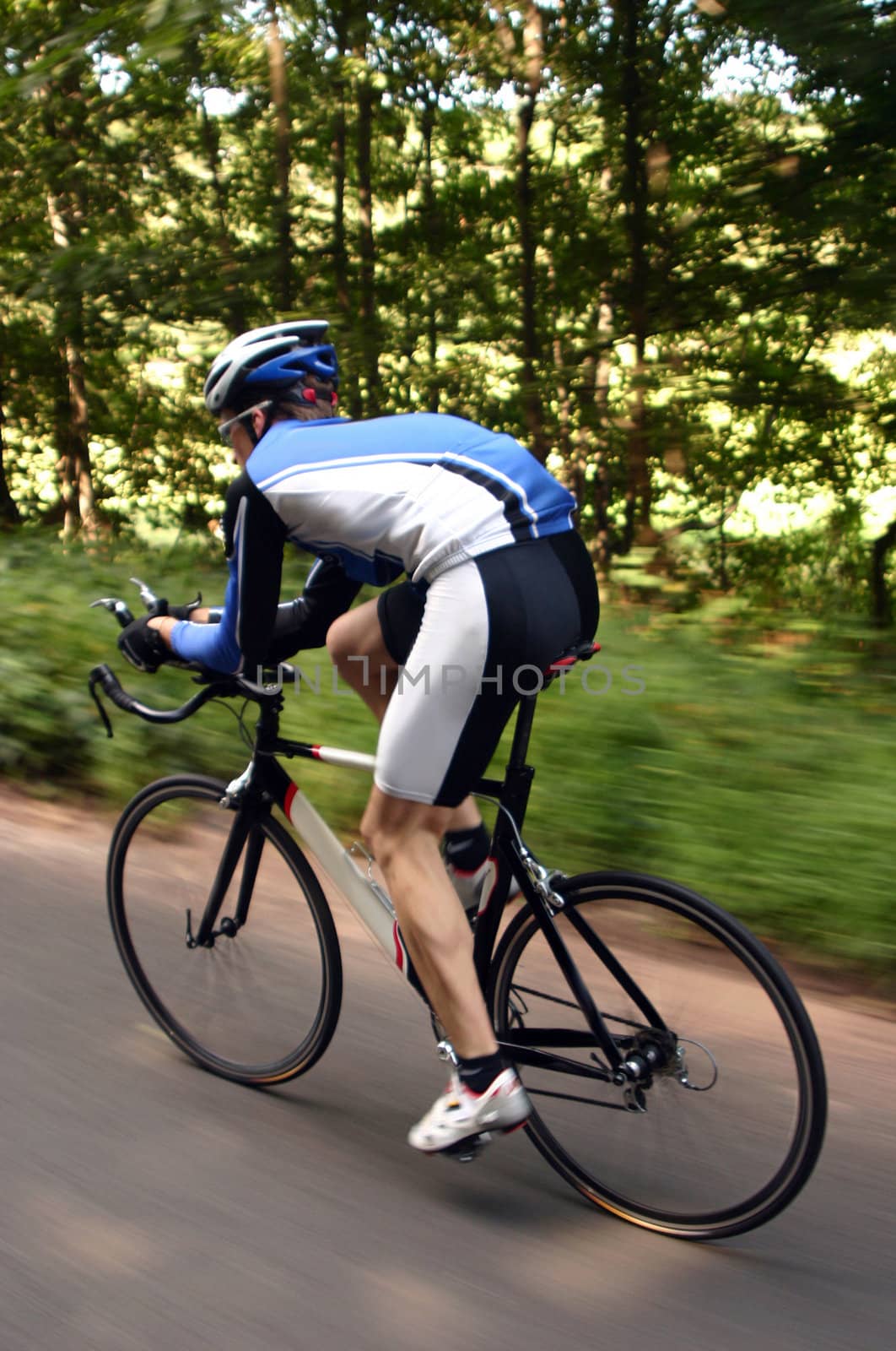 An action shot of a cyclist on a road bike during a race. 