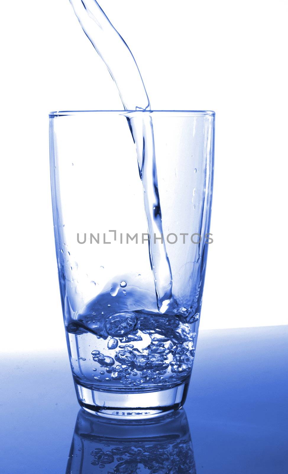 pouring fresh water in a glass on white