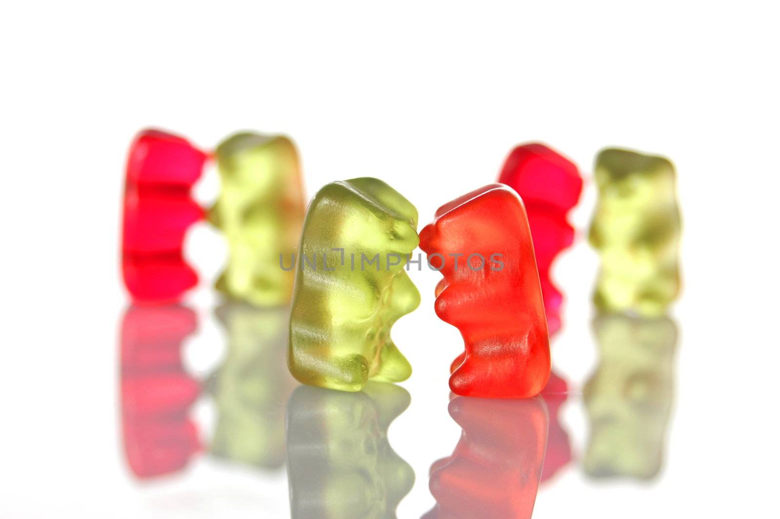 sweet gummy bears dancing on a party on white background