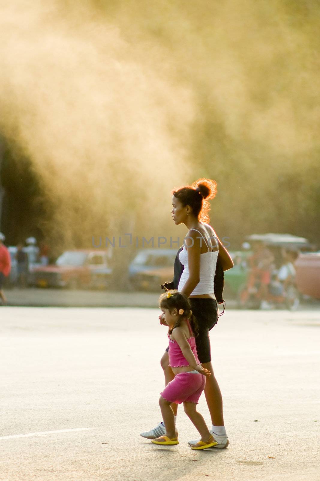 Little girl with mother in city smog. January 2008, Havana, Cuba.