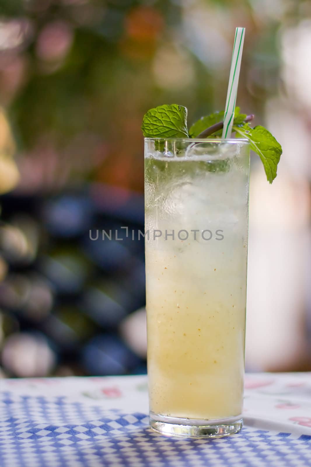 A glass of mojito cocktail with mint on colored background