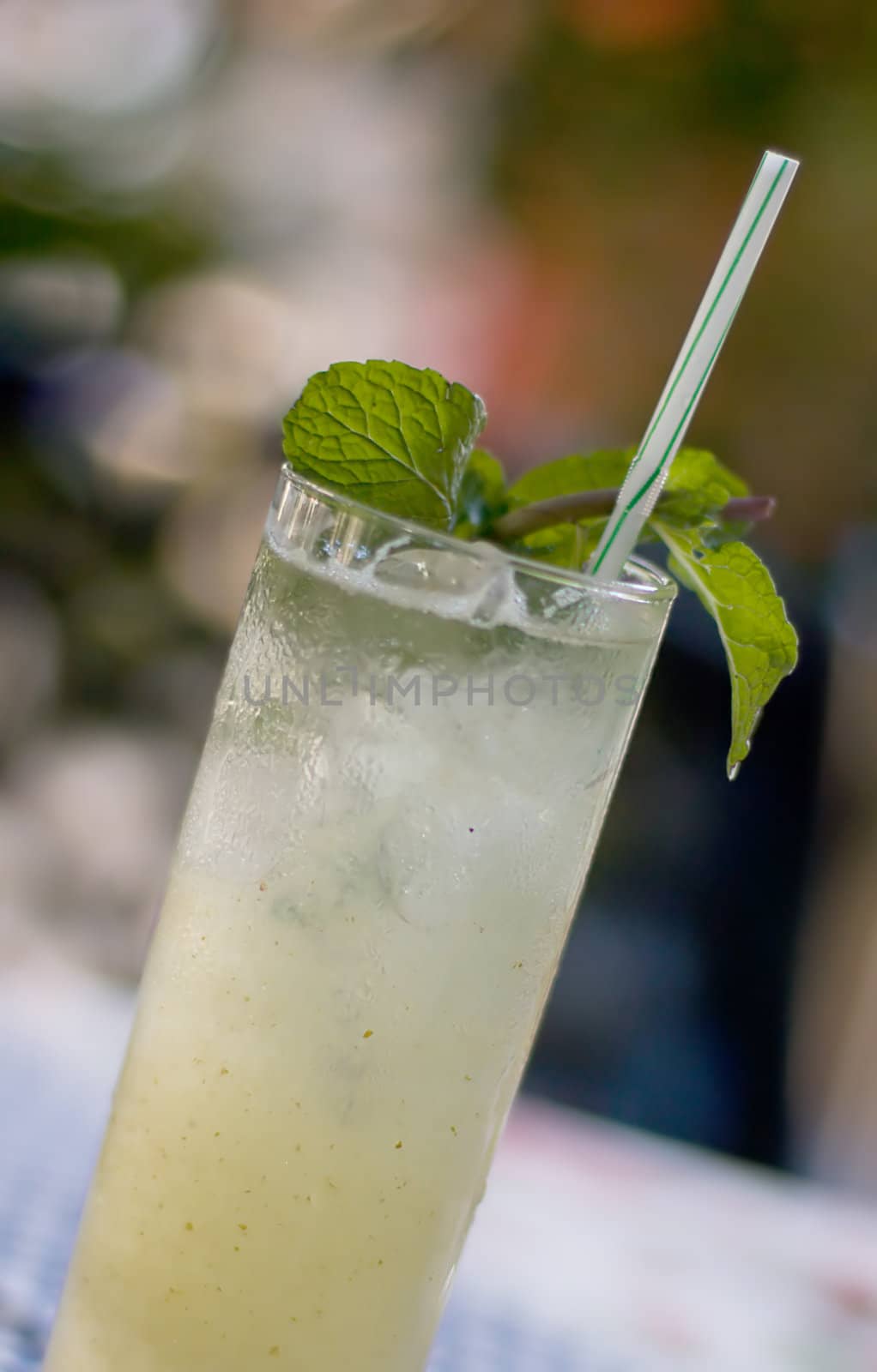 A glass of fresh mojito cocktail with mint on colored background