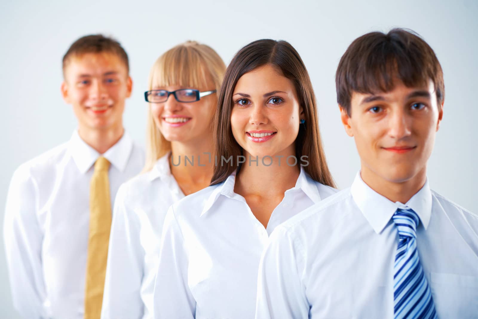 Portrait of young business woman with her colleagues standing in a row
