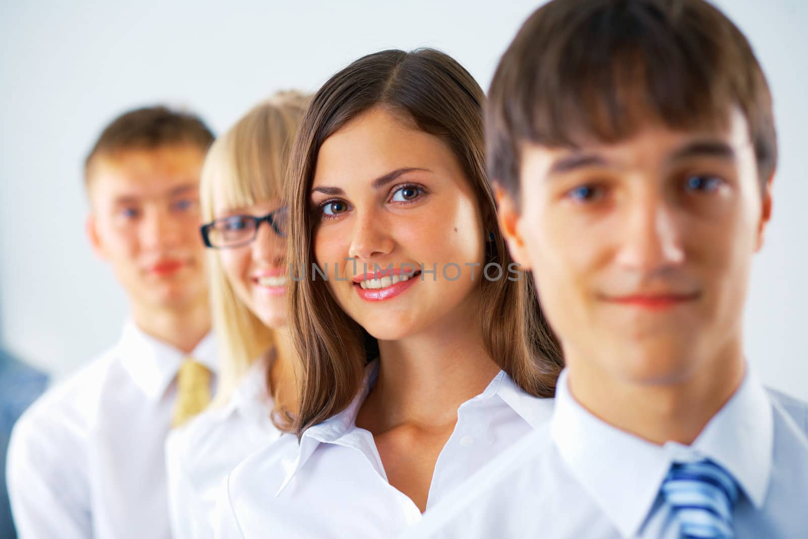 Portrait of young business woman with her colleagues standing in a row