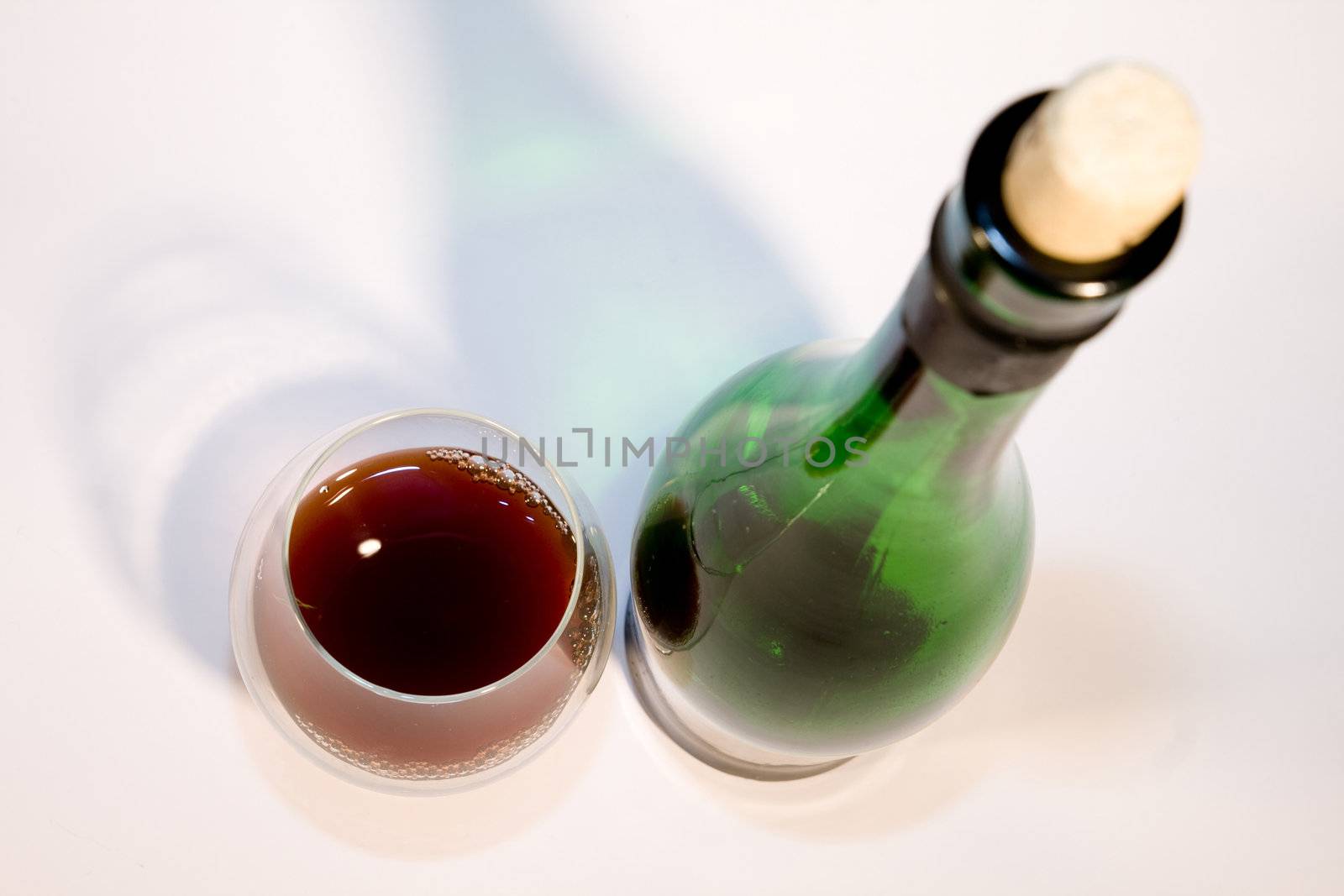 Glass of wine about a bottle on a white background