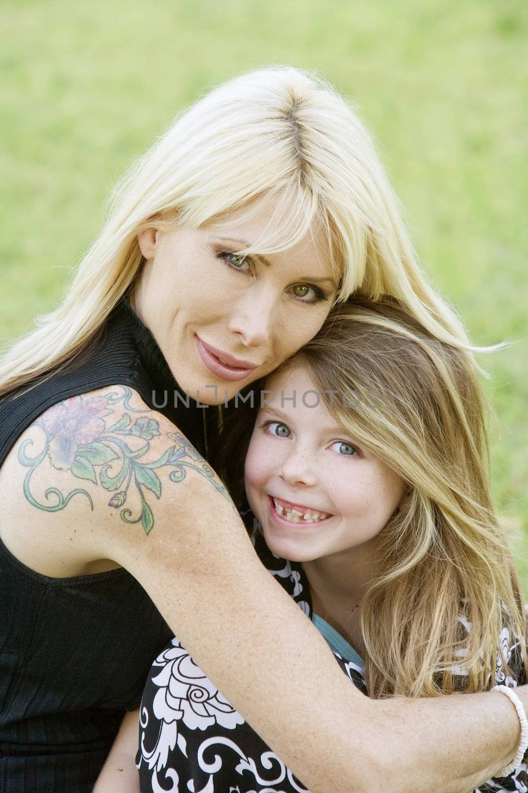 Pretty mom hugs her cute freckle-faced daughter