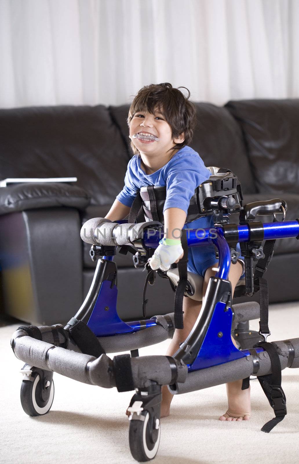 Disabled three year old child enjoying standing in  his walker