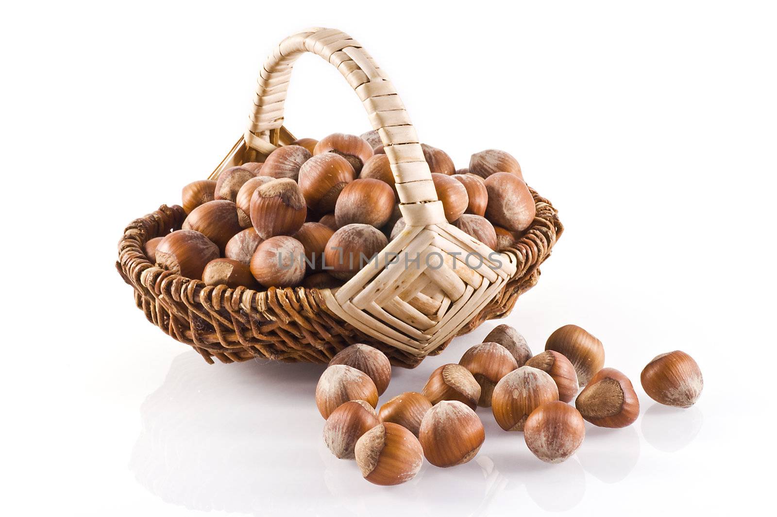 Little basket filled with hazelnuts on a white background.