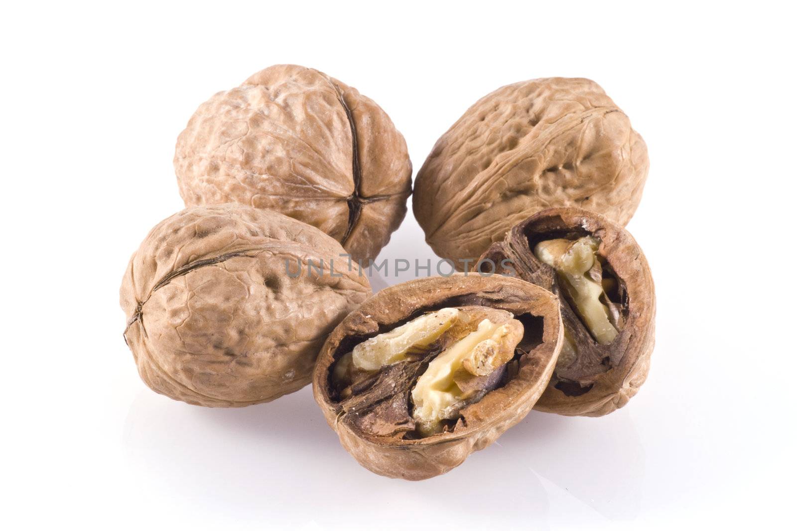 Walnuts, three whole nuts and one cracked, isolated on white.