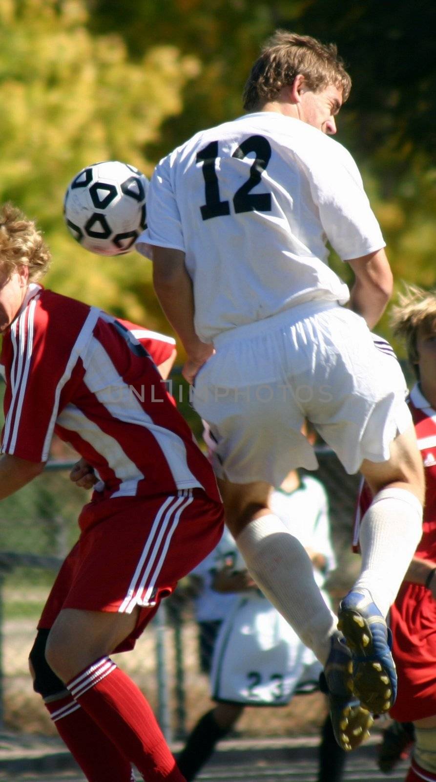 Soccer player collides with another while jumping for ball