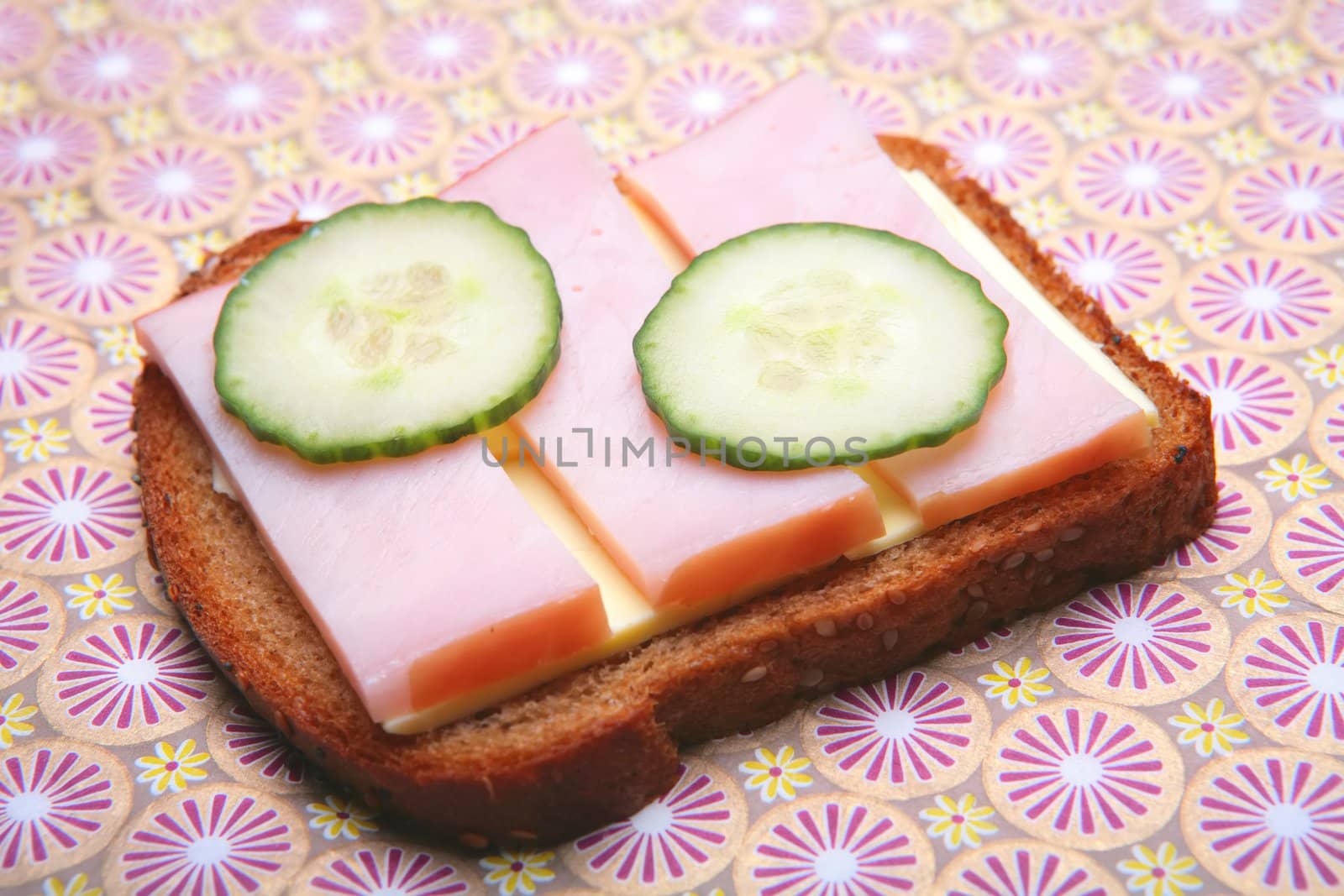 sandwich from pumpernickel bread with butter, ham and cucumber